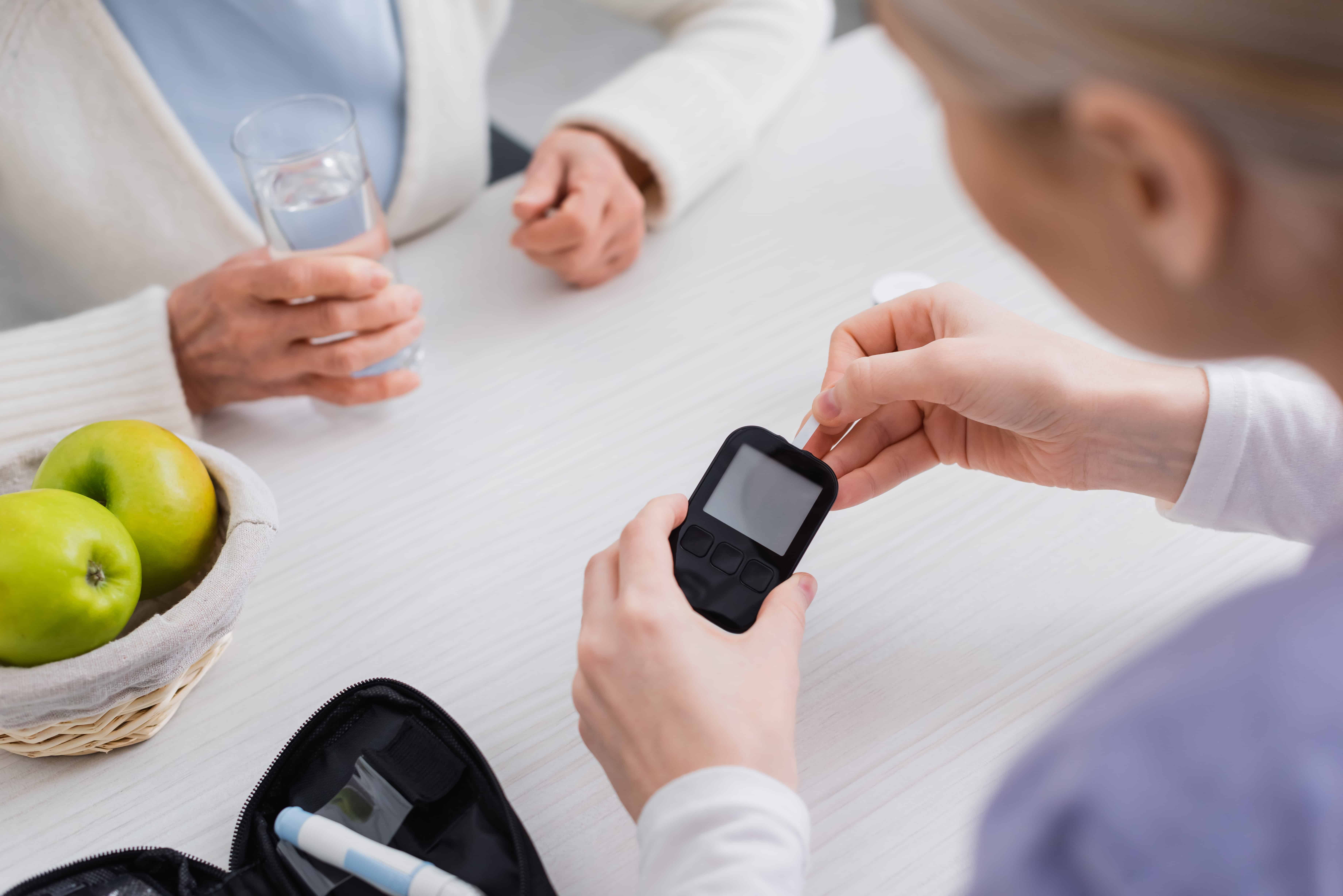 Hipoglucemia: que hacer 2 crello 470112540 stock photo partial view nurse holding glucometer